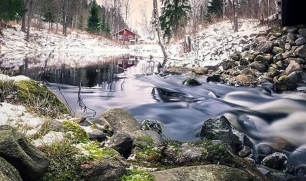 Scenic landscape with river and abandoned cottage at winter