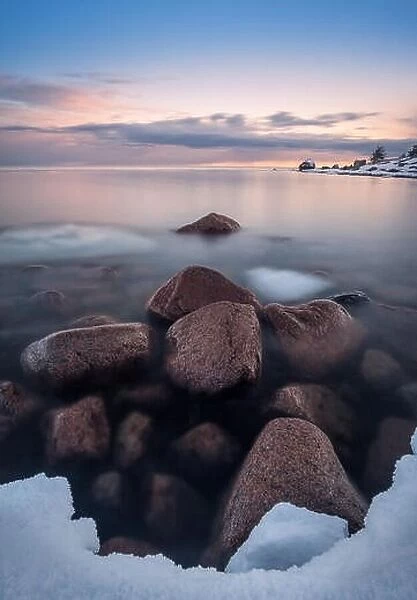 Scenic landscape with sea and beach stones at sunset time in Finland