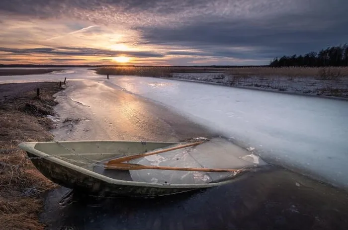 Framed Print : Scenic landscape with sunset and abandoned boat at spring evening in Finland. Boat is almoust in the ice Framed Print : Scenic landscape with sunset and abandoned boat at spring evening in Finland. Boat is almoust in the ice