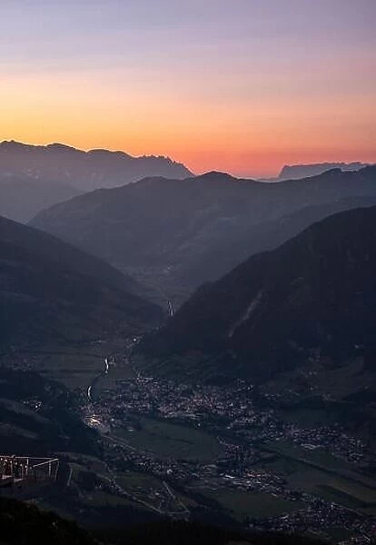 Scenic mountain landscape with orange sunset and idyllic valley village at summer evening in Austria alps