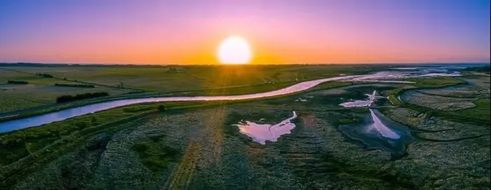 Framed Print : Scenic river flowing among meadows and pastures at sunset - wide aerial panorama Framed Print : Scenic river flowing among meadows and pastures at sunset - wide aerial panorama