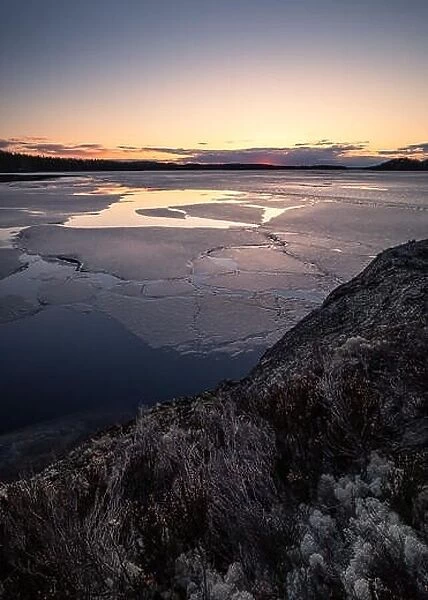 Scenic spring landscape with melted ice and sunset at evening light in Finland