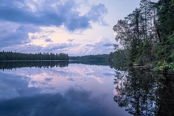 Scenic summer night landscape with mood light and beautiful reflections at lakeside in Finland