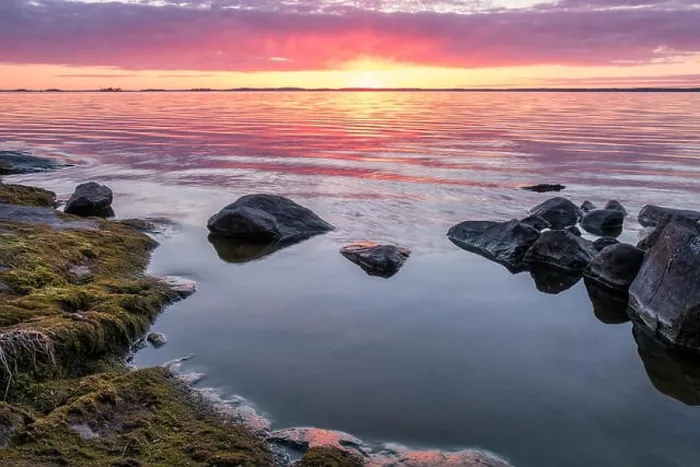 Framed Print : Scenic sunset with peaceful lake and rock at spring evening in Finland Framed Print : Scenic sunset with peaceful lake and rock at spring evening in Finland