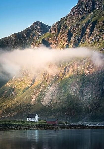 Scenic view with idyllic house and mountains at summer evening in Lofoten, Norway