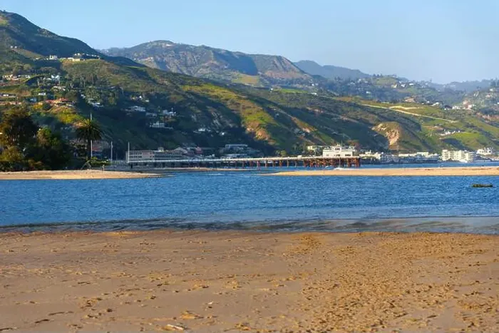 Framed Print : Scenic view of Malibu Pier extending over calm waters with sandy beach and hills in background