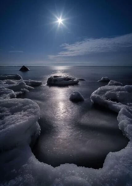 Scenic view with moonlight and icy sea at winter night in coastline, Finland