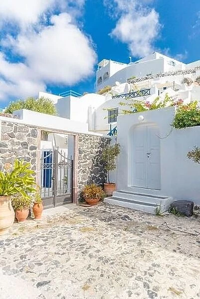 Scenic view of traditional cycladic Santorini houses on small street, old stone path, white architecture and blue sky. Summer travel vacation, idyllic