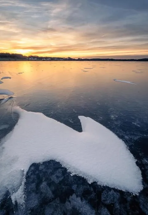 Framed Print : Scenic winter landscape with frozen lake and water at evening sunset in Finland Framed Print : Scenic winter landscape with frozen lake and water at evening sunset in Finland