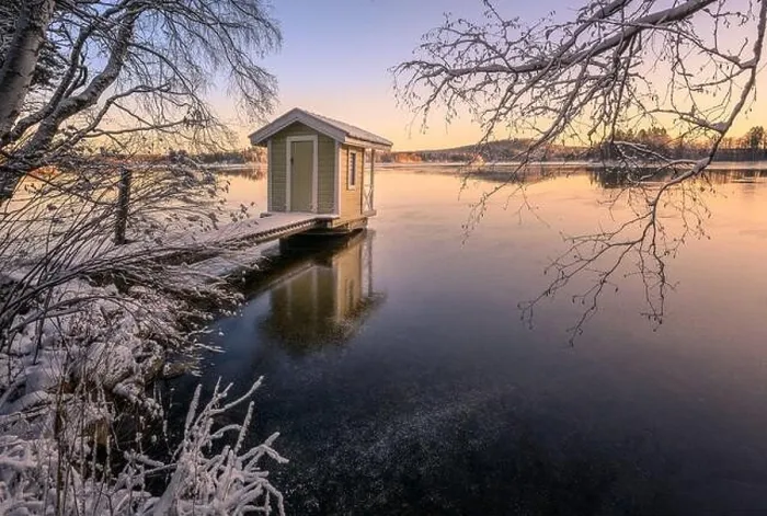 Framed Print : Scenic winter landscape with sunset and cozy cottage at icy and peaceful lake in Finland