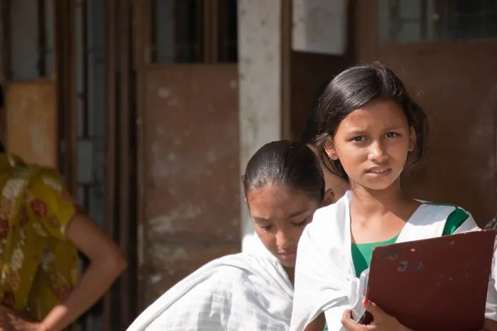 Framed Print : School girl in a Bangladeshi village, holding a board, with friend in the background Framed Print : School girl in a Bangladeshi village, holding a board, with friend in the background