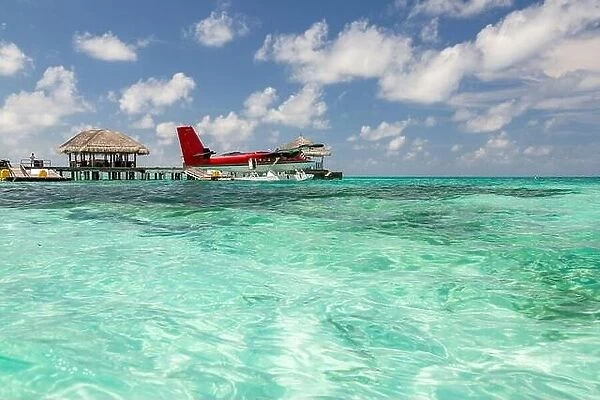 Seaplane at Maldives islands. Amazing blue lagoon, with red seaplane. Luxury travel and summer vacation concept
