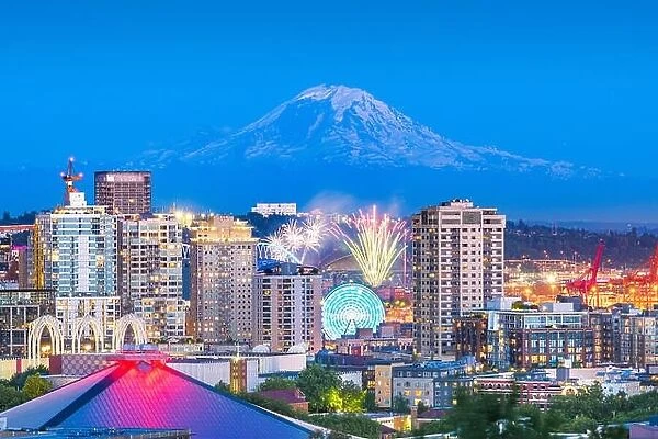 Seattle, Washington, USA downtown skyline with Mt. Rainier and a fireworks show below