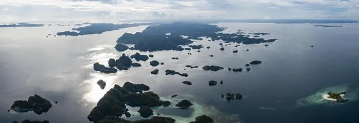 Framed Print : Seen from above, remote islands are surrounded by coral reefs in Raja Ampat, Indonesia. This region is known as the heart of the Coral Triangle Framed Print : Seen from above, remote islands are surrounded by coral reefs in Raja Ampat, Indonesia. This region is known as the heart of the Coral Triangle