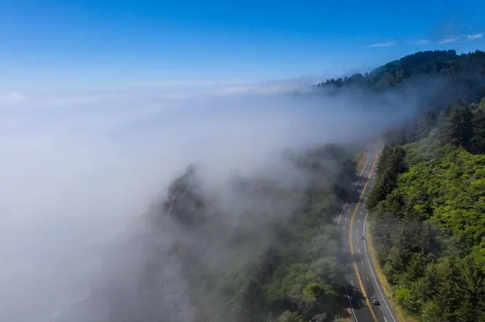 Framed Print : Seen from a bird's eye view, the foggy marine layer seeps over the Pacific Coast Highway that runs along the scenic coastline in Northern California Framed Print : Seen from a bird's eye view, the foggy marine layer seeps over the Pacific Coast Highway that runs along the scenic coastline in Northern California