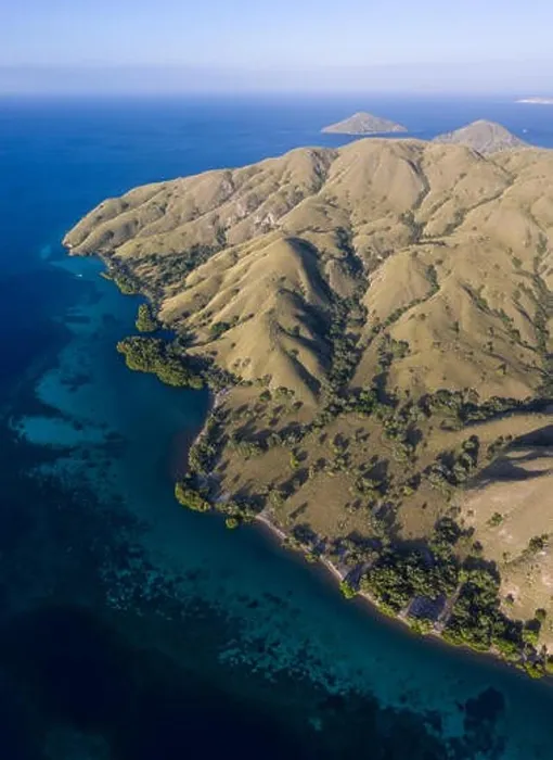 Framed Print : Seen from a bird's eye view, the blue Pacific Ocean surrounds the rugged island of Komodo in Indonesia. This tropical area is known for its diversity Framed Print : Seen from a bird's eye view, the blue Pacific Ocean surrounds the rugged island of Komodo in Indonesia. This tropical area is known for its diversity