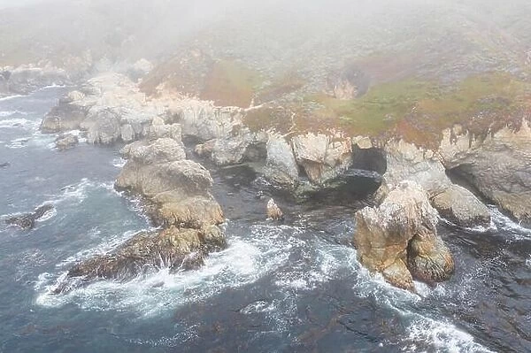Seen from a bird's eye view, the cold waters of the Pacific Ocean wash against the rocky yet beautiful coast south of Monterey in Northern California