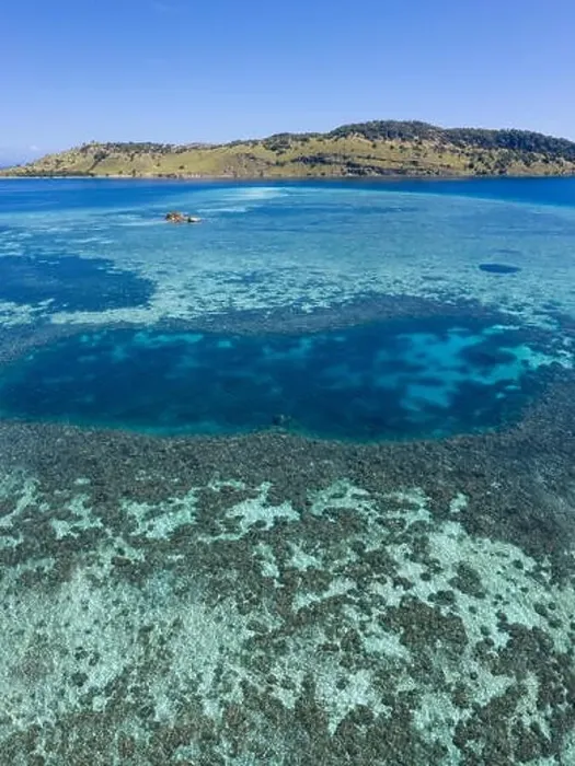 Framed Print : Seen from a bird's eye view, an idyllic tropical island is surrounded by a healthy coral reef in Komodo National Park