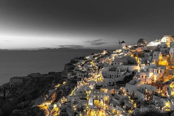 Selective color image, orange color with black and white process. Night lights over Oia village Santorini, Greece. Famous travel destination, artistic