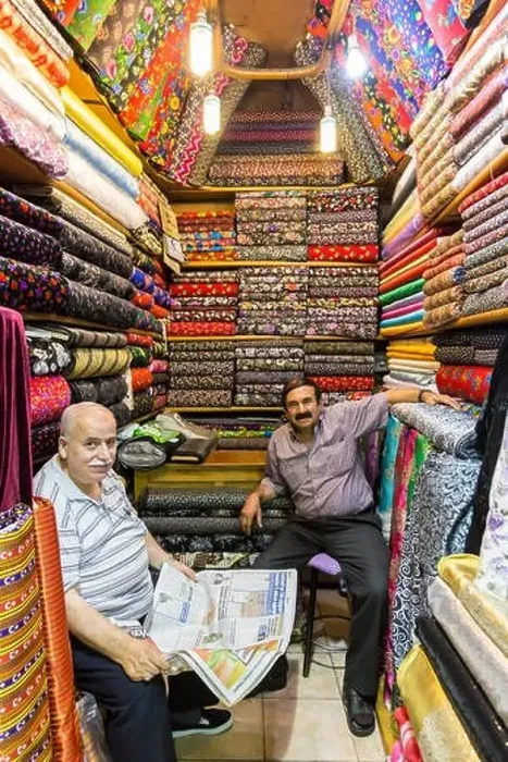 Framed Print : Sellers (vendors) of traditional Turkish fabrics seated in their shop reading a newspaper Framed Print : Sellers (vendors) of traditional Turkish fabrics seated in their shop reading a newspaper