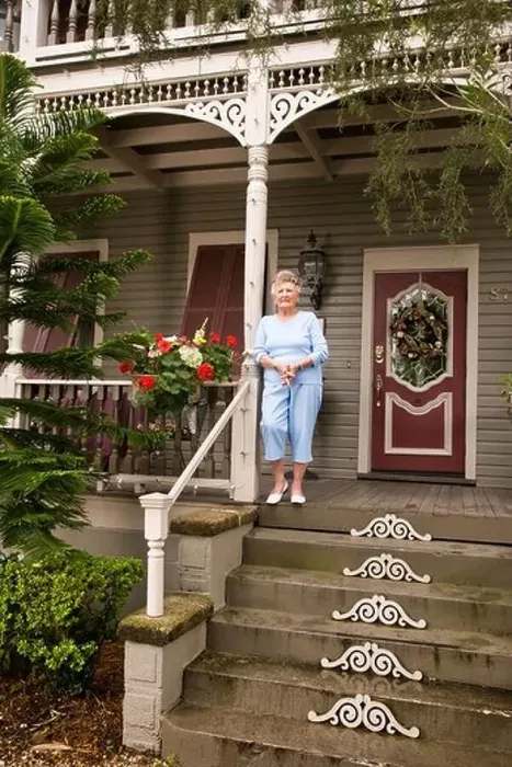 Framed Print : Senior woman standing on front porch of house Framed Print : Senior woman standing on front porch of house