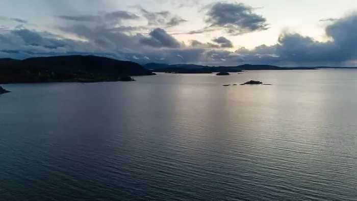 Framed Print : A serene fjord at dusk with scattered clouds and distant hills Framed Print : A serene fjord at dusk with scattered clouds and distant hills