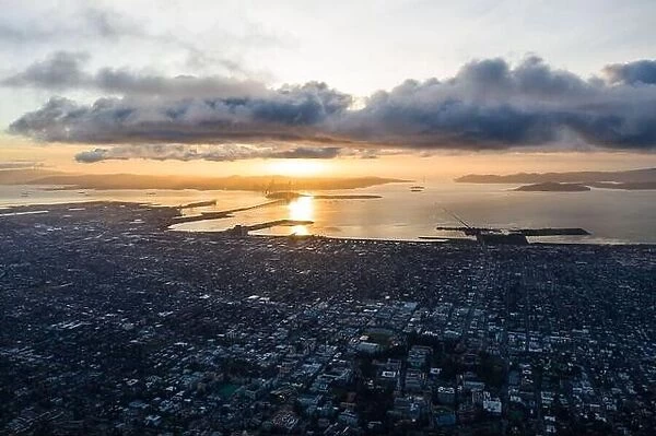A serene sunset illuminates the densely populated San Francisco Bay area including Oakland, Berkeley, Emeryville, El Cerrito, and San Francisco