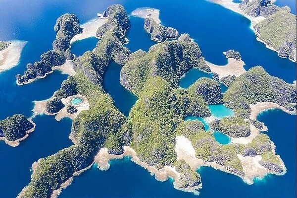 Shallow coral reefs surround remote limestone islands in Raja Ampat, Indonesia. This biodiverse region is known as the 'heart of the Coral Triangle.'