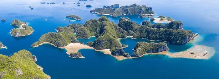 Framed Print : Shallow coral reefs surround remote limestone islands in Raja Ampat, Indonesia. This biodiverse region is known as the heart of the Coral Triangle