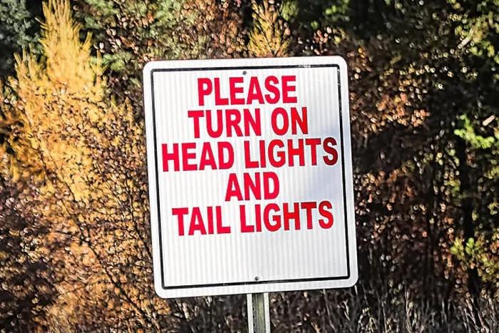 Framed Print : A sign indicating to turn on all vehicle lights