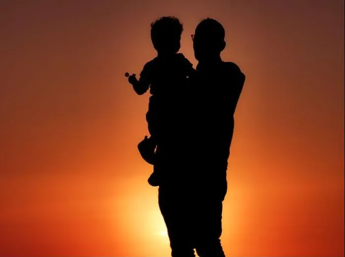 Framed Print : A silhouette of a grandfather holding his grandson with a lollipop at sunset on the coast of Cape Zebib Framed Print : A silhouette of a grandfather holding his grandson with a lollipop at sunset on the coast of Cape Zebib