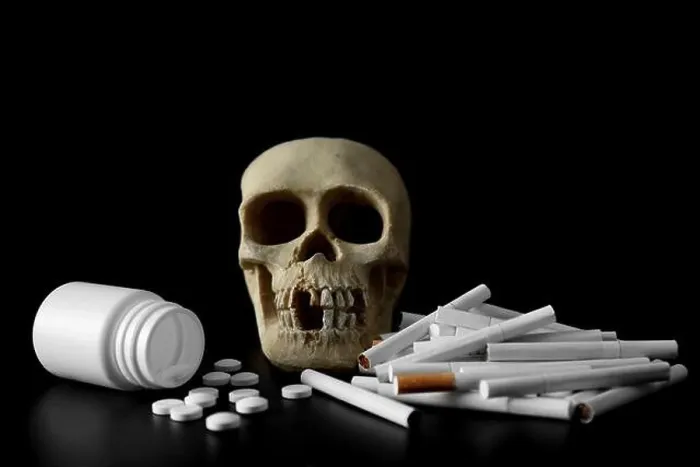 Framed Print : Skull, pile of cigarettes and pills on black background Framed Print : Skull, pile of cigarettes and pills on black background