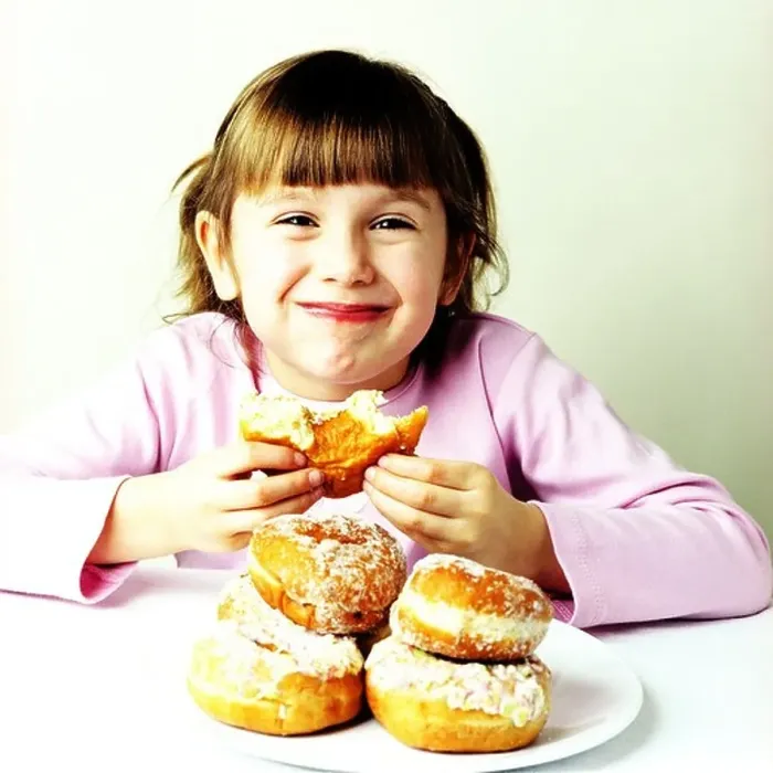 Framed Print : A small girl eating doughnuts Framed Print : A small girl eating doughnuts