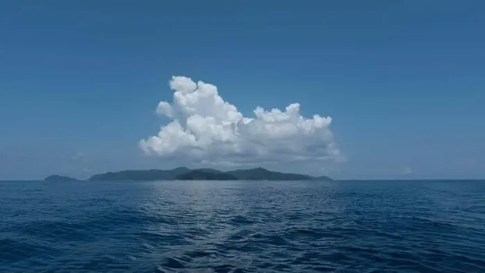 Framed Print : Small island in the middle of the sea with blue sky and white clouds above Framed Print : Small island in the middle of the sea with blue sky and white clouds above