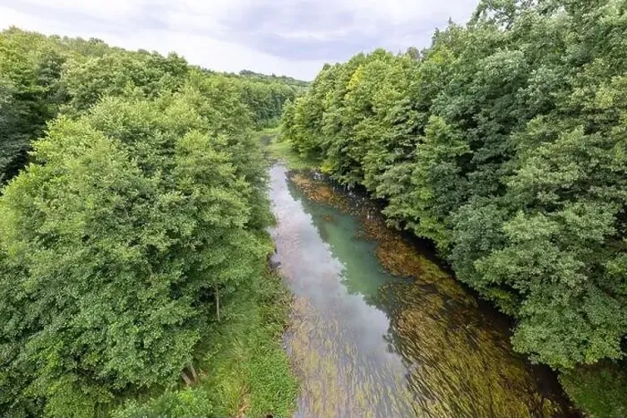 Framed Print : A small river seen from the railway bridge. The river bed is covered with deciduous trees. Summer season Framed Print : A small river seen from the railway bridge. The river bed is covered with deciduous trees. Summer season