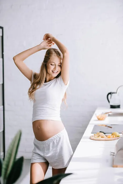 Framed Print : smiling beautiful pregnant woman in white clothing standing in kitchen at home Framed Print : smiling beautiful pregnant woman in white clothing standing in kitchen at home