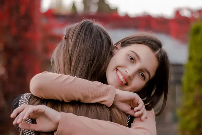 Framed Print : Smiling cute girl hugs his girlfriend tightly Framed Print : Smiling cute girl hugs his girlfriend tightly