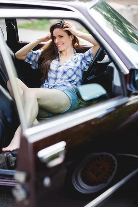 Framed Print : Smiling girl in short shorts in open car, tinted photo Framed Print : Smiling girl in short shorts in open car, tinted photo