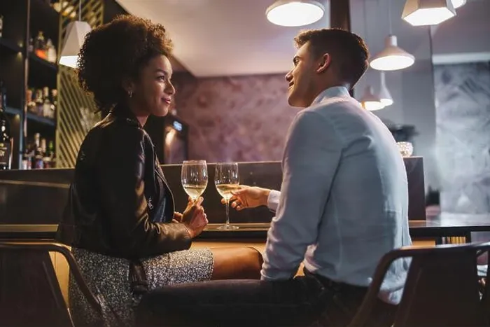 Framed Print : Smiling interracial couple enjoying a romantic wine toast in a cozy bar, celebrating a special moment together Framed Print : Smiling interracial couple enjoying a romantic wine toast in a cozy bar, celebrating a special moment together