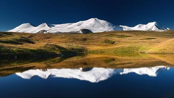 Snowy mountains reflected in lake