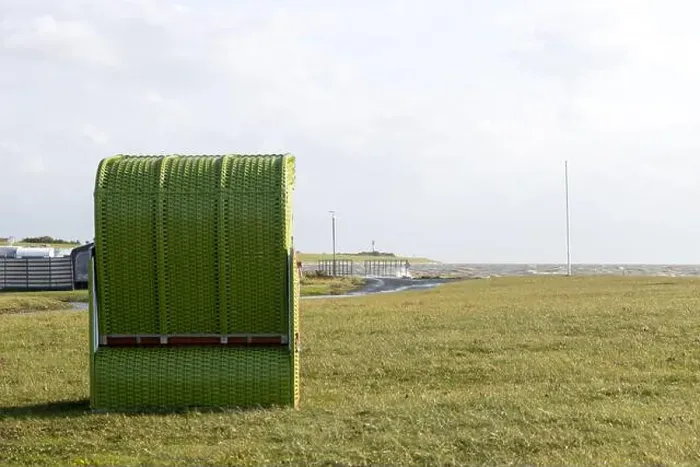 Framed Print : A solitary green beach chair stands on a grassy field by the sea Framed Print : A solitary green beach chair stands on a grassy field by the sea
