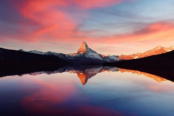 Splendid landscape with colorful sunrise on Stellisee lake. Snowy Matterhorn Cervino peak with reflection in clear water. Zermatt, Swiss Alps