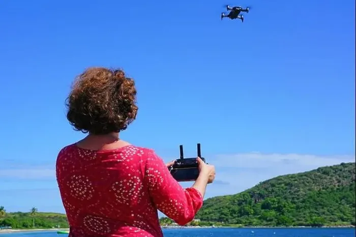 Framed Print : ST KITTS, ST KITTS AND NEVIS -21 NOV 2018- A woman taking pictures with a drone camera over the Caribbean Sea in Framed Print : ST KITTS, ST KITTS AND NEVIS -21 NOV 2018- A woman taking pictures with a drone camera over the Caribbean Sea in