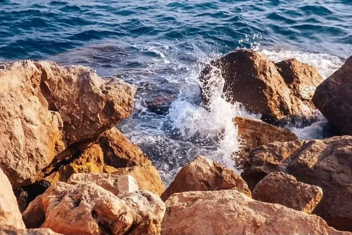 Framed Print : Stormy sea with waves and splashes breaks on sharp stones, warm day, light of sun Framed Print : Stormy sea with waves and splashes breaks on sharp stones, warm day, light of sun