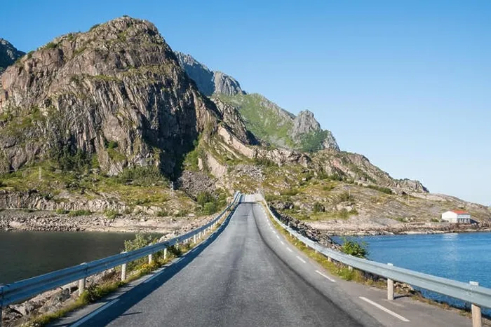 Framed Print : Straight asphalt road with mountain and sea against blue sky in Lofoten, Norway Framed Print : Straight asphalt road with mountain and sea against blue sky in Lofoten, Norway