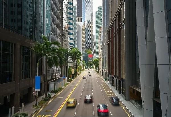 Street and car on traffic moving in downtown business financial district with skyscraper building in morning at Singapore