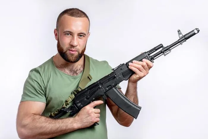 Framed Print : Strong caucasian shooter in casual clothing with sniper rifle looking at camera isolated on white