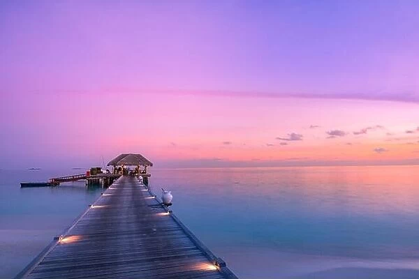 Stunning colorful sunset sky with clouds seaside bay horizon. Lagoon landscape in Maldives. Luxury traveling destination, exotic summer beach view