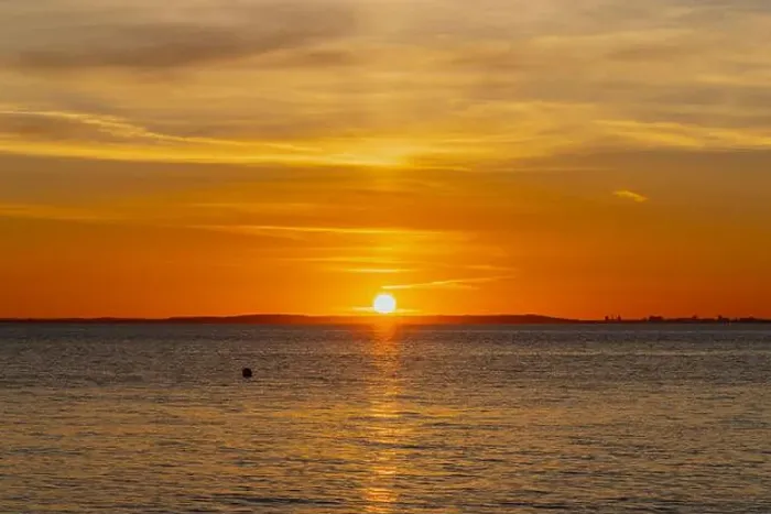 Framed Print : The sun about to set over the Welsh coast with a reddish orangey glow along the horizon Framed Print : The sun about to set over the Welsh coast with a reddish orangey glow along the horizon