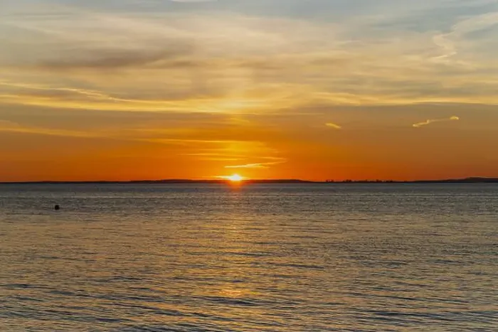 Framed Print : The sun about to set over the Welsh coast with a reddish orangey glow along the horizon Framed Print : The sun about to set over the Welsh coast with a reddish orangey glow along the horizon